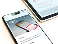Smartphone mit KUZ News auf Screen